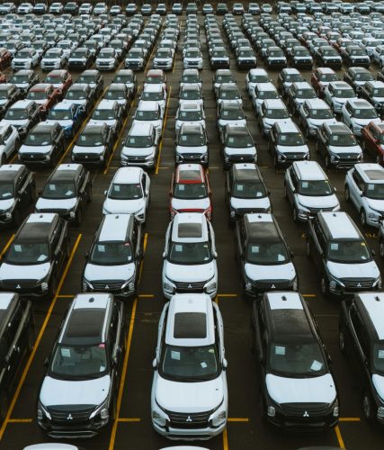 Aerial shot showcasing a vast storage lot filled with parked cars lined up in rows.
