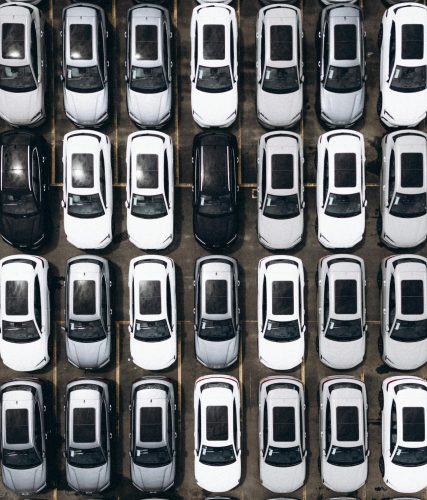 Aerial shot of a parking lot with rows of parked cars in Brazil, showcasing organization and modernity.